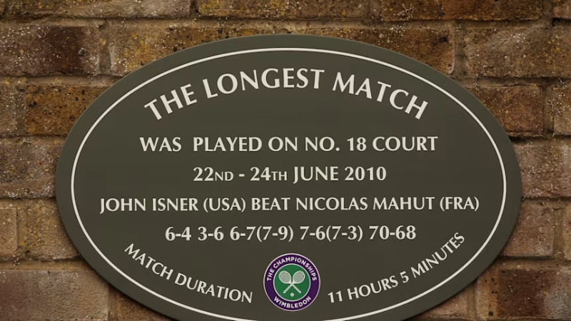 Một tấm bảng treo bên ngoài sân số 18 để vinh danh trận đấu giữa John Isner và Nicolas Mahut trong Wimbledon 2010.